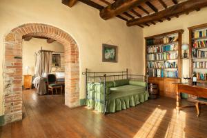 a living room with a green couch and a book shelf at B&B - Podere Monti in Montepulciano