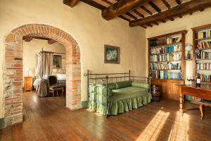 uma sala de estar com um sofá verde e uma estante de livros em B&B - Podere Monti em Montepulciano