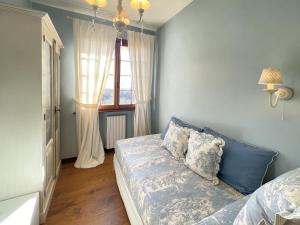 um quarto azul com uma cama e uma janela em Villa Villacolle by BarbarHouse em Mondolfo