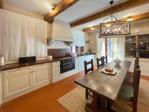 uma cozinha com uma mesa de madeira e uma sala de jantar em Villa Villacolle by BarbarHouse em Mondolfo