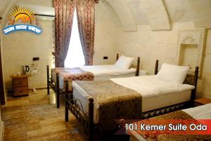 una camera d'albergo con tre letti e una finestra di Sun Rise View Hotel a Göreme