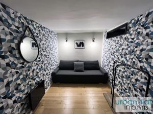 a room with a black couch in a room with tiles at 89 - Urban Treasure in Montorgueil in Paris