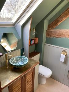 a bathroom with a sink and a toilet at Whichford Mill Barn- Soulful retreat. in Shipston-on-Stour