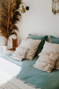uma cama verde com almofadas brancas em Mas Andalou Fabuleuse première ligne de mer, plage privative em Frontignan