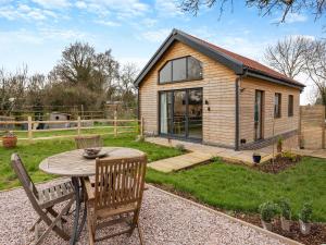 a tiny house with a table and two chairs at Bluebell Annexe in Sandy