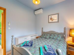 a bedroom with a bed with a blue comforter at Bluebell Annexe in Sandy