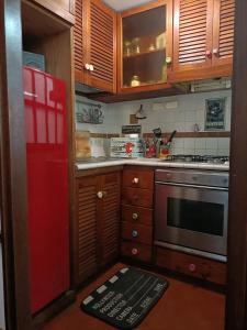 uma cozinha com um frigorífico vermelho e armários de madeira em The Place em Roma