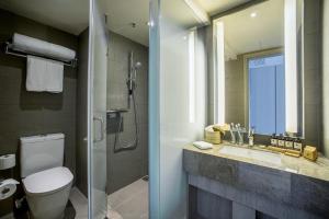 a bathroom with a toilet and a sink and a shower at One Dundas in Hong Kong