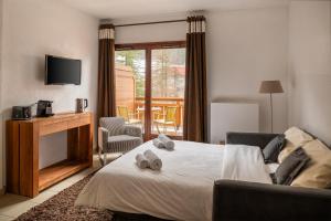 ein Schlafzimmer mit Bett, Fernseher und Stuhl in der Unterkunft Dormio Resort Les Portes du Mont Blanc in Vallorcine