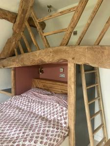 uma cama alta com uma escada num quarto em Whichford Mill Barn- Soulful retreat. em Shipston on Stour
