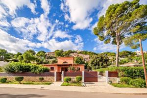 a house with a fence and trees at Beach Villa Margot by Sealand Villas in Port de Pollensa +22 photos