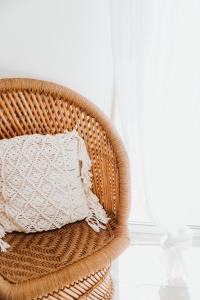 uma cadeira de vime com uma almofada branca em frente a uma janela em Mas Andalou Fabuleuse première ligne de mer, plage privative em Frontignan