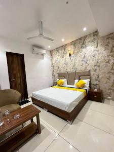 a bedroom with a large bed and a chair at THE LUXURY PLATINUM INN --Luxury Deluxe Rooms -- Chandigarh Road in Ludhiana