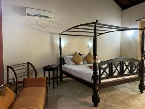 a bedroom with a bed and a couch at Traum Villa in Bentota