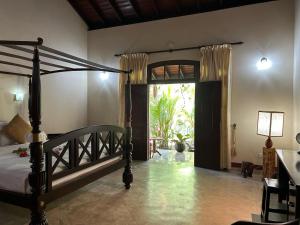 una camera con letto a baldacchino e porta di accesso a un patio di Traum Villa a Bentota Altre 203 foto