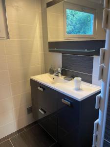 a bathroom with a sink and a window at Maison de village cosy et chaleureuse in Tavera