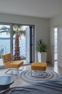 a living room with two chairs and a palm tree at Villa Roca in Vis
