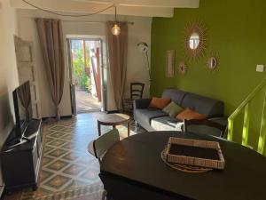 a living room with a couch and a table at Maison de village cosy et chaleureuse in Tavera