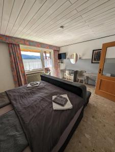 a bedroom with a large bed and a window at Hotel Sonnenmatte Titisee B und B nahe Badeparadies in Titisee