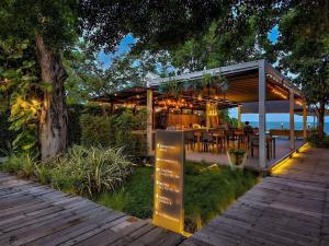 a pavilion with a table and chairs on a deck at De Chaochom Hua Hin in Hua Hin