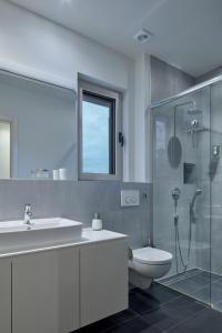 a bathroom with a sink and a toilet and a shower at Villa Roca in Vis