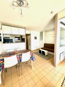 cocina con mesa, sillas y sofá en CAMARG'Beach Vue mer-Piscines-Plages-Tennis-Parking-4PERS, en Le Grau-du-Roi 18 fotos más