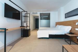 1 dormitorio con 1 cama y TV de pantalla plana en HOTEL ALOVE en San José