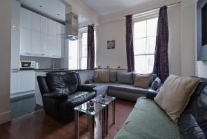 a living room with a couch and a table at Queensway Flat by DC London Rooms in London