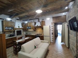 a living room with a couch and a kitchen at Dimora de' Canulei in Bolsena