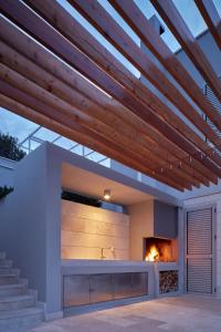 a patio with a fireplace and a wooden ceiling at Villa Roca in Vis