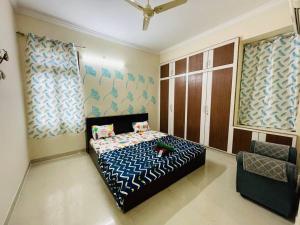 a bedroom with a bed and a chair in it at Beautiful 2bhk near Hitech city in Kondapur