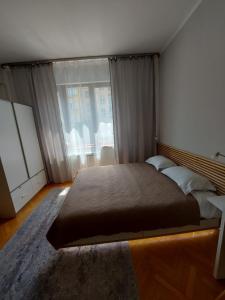 una camera da letto con un letto grande e una grande finestra di Studio 72 a Sofia