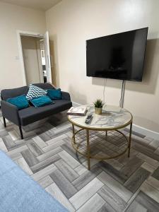 uma sala de estar com um sofá e uma mesa em Tudors eSuites Budget Apartments em Birmingham