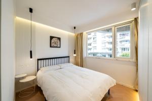 a white bedroom with a bed and a window at Shanghai Yi Du B&B - Near near Jiaotong University and Hongqiao Station in Shanghai