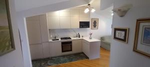 a kitchen with white cabinets and a stove at Apartments Skiljan in Crikvenica
