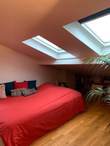 - une chambre avec un grand lit rouge et des lucarnes dans l'établissement Duplex avec Terrasse proche JO, à Le Pré-Saint-Gervais