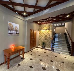 a living room with a staircase and a wooden table at Comfort Eland Hotel in Arusha