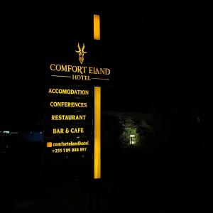 a sign for a concertland hotel at night at Comfort Eland Hotel in Arusha