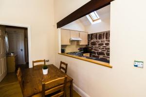 a kitchen and dining room with a wooden table at Toes Rock Sandy Haven in Herbrandston