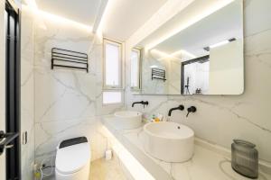 a white bathroom with two sinks and a mirror at Shanghai Yi Du B&B - Near near Jiaotong University and Hongqiao Station in Shanghai