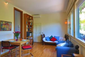 ein Wohnzimmer mit einem blauen Sofa und einem Tisch in der Unterkunft Romantico attico con terrazzo in Centro in Mailand