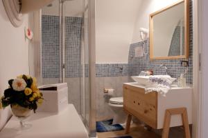 a bathroom with a sink and a toilet and a mirror at Appartamento Alla Corte dei Misteri in Trapani