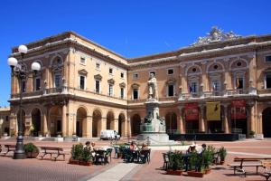 a large building with a statue in front of it at Maison all'Arco in Corridonia +9 photos