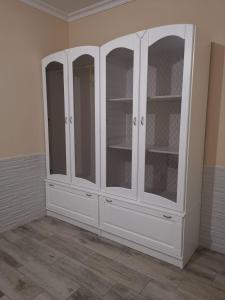 biała szafka ze szklanymi drzwiami w pokoju w obiekcie Suit Garden Huelva w mieście Aljaraque