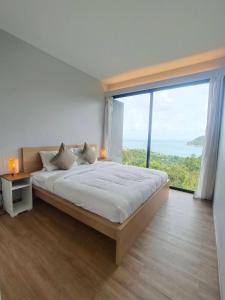 トン・ナイ・パン・ノイにあるOzone Hill Panoramic Residence Thong Nai Pan Beachのベッドルーム1室(大きなベッド1台、大きな窓付)