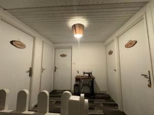 a hallway with white walls and a table and chairs at Aux Lacs et Cascades in Songeson
