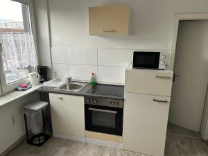 a small kitchen with a sink and a refrigerator at Monteurwohnung Haus Elbert 3 in Hagen