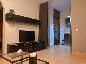 a living room with a tv and a glass table at Apartamento Ataraxia in Ronda