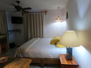 a bedroom with a bed with a lamp and a table at Casita La Adornada in Taxco de Alarcón