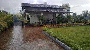 ein Haus an einem regnerischen Tag mit Garten in der Unterkunft R S COMFORTS in Mysore